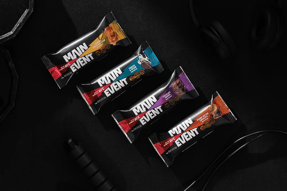 UFC Main Event protein bars in black wrappers with gym equipment