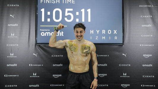 Marc Lou celebrating after finishing HYROX Izmir in 1:05:11 with sponsor logos painted across his race kit