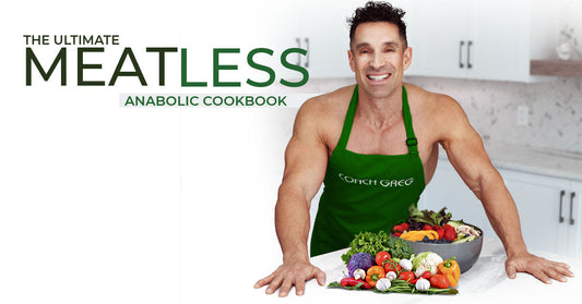 Greg Doucette in a green apron standing behind a bowl of fresh vegetables in a kitchen