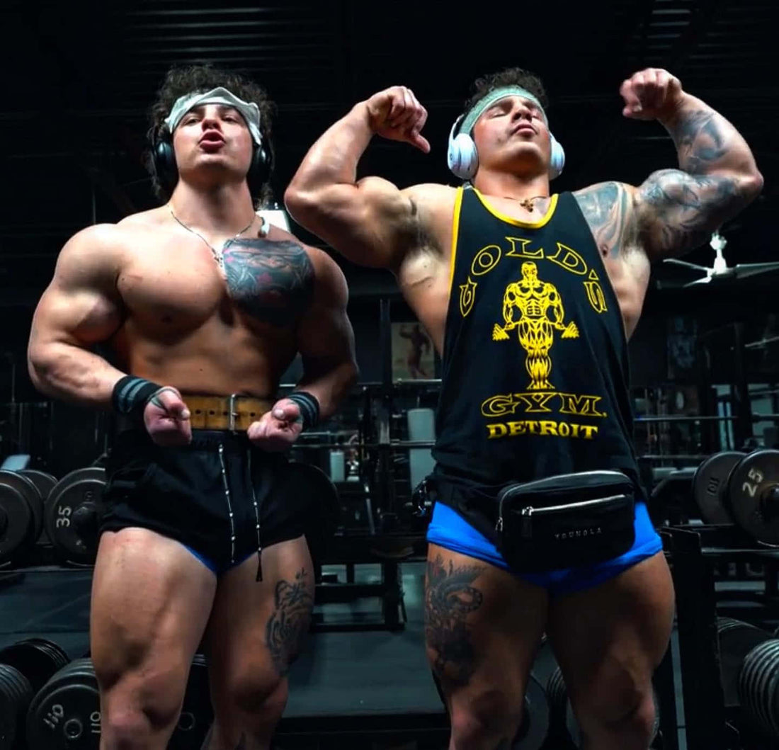 Christian and Michael Gaiera, the Tren Twins, flexing side by side in a dark weight room