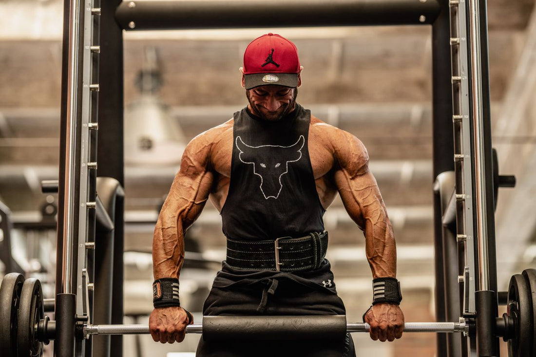 Muscular male bodybuilder lifting a barbell in a gym