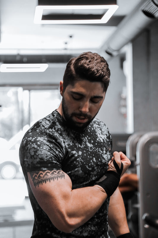 Muscular man flexing his biceps in a weight-training gym