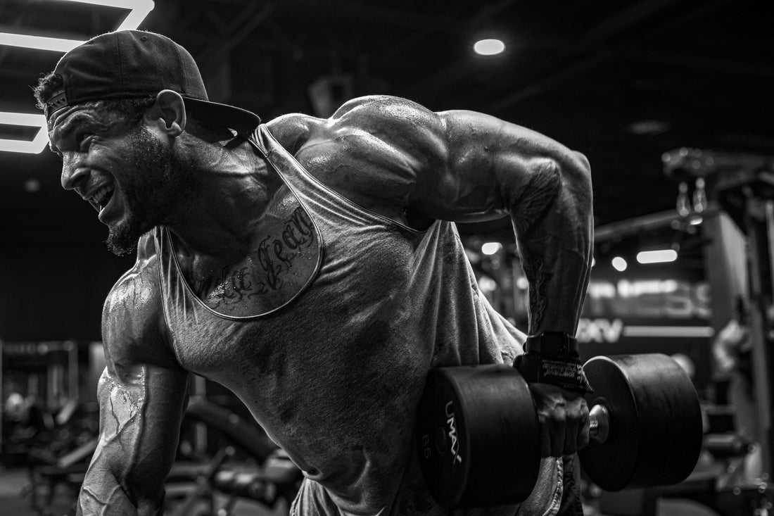 Muscular athlete performing a heavy dumbbell row in a gym