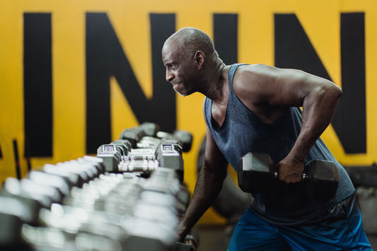 Senior man lifting a dumbbell during a strength workout in a gym