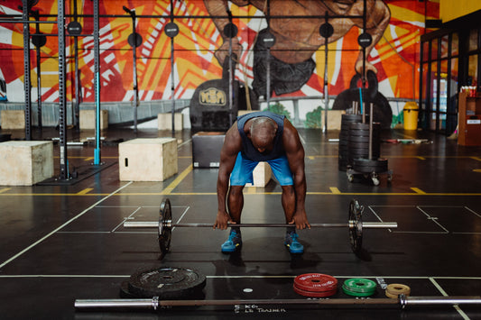 Athlete holding a loaded barbell in a gym while preparing for strength training