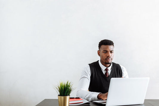 Office worker seated at a desk using a laptop during a long work session