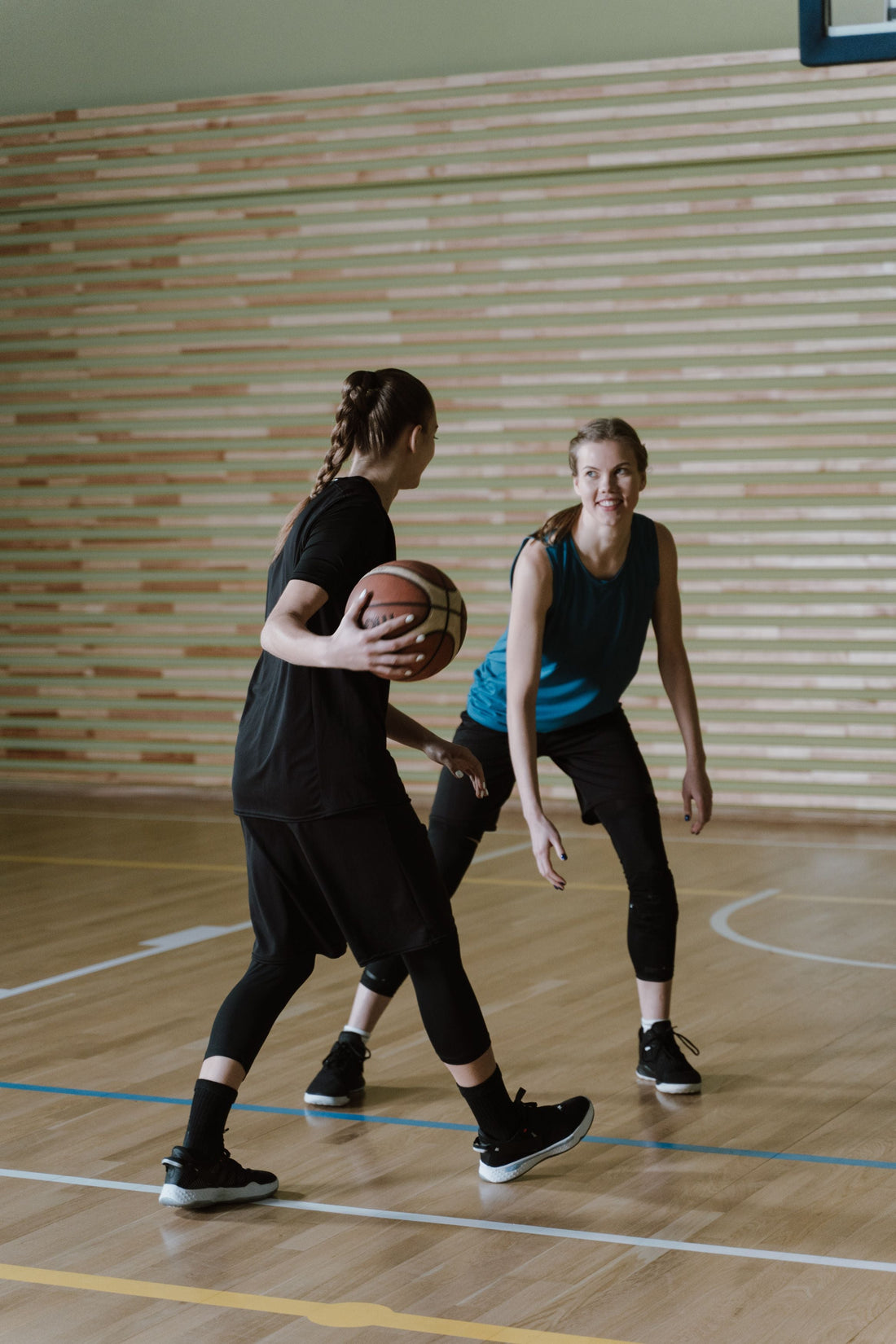 Women playing basketball during an indoor training session