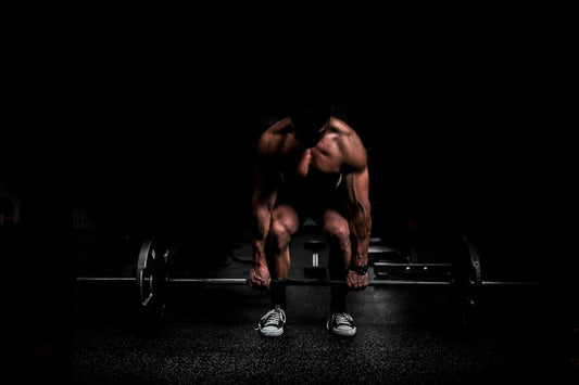 Illustrative gym photograph of a muscular athlete training with weights
