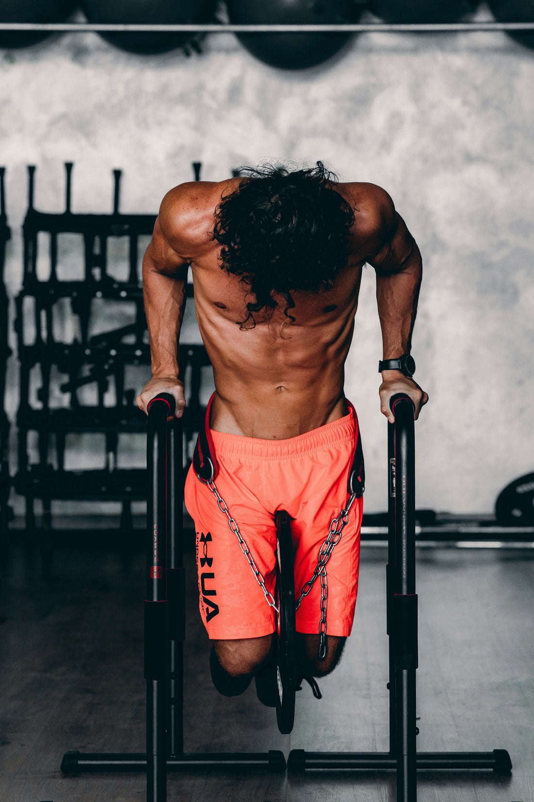 Calisthenics athlete performing weighted dips on parallel bars during a bodyweight strength workout