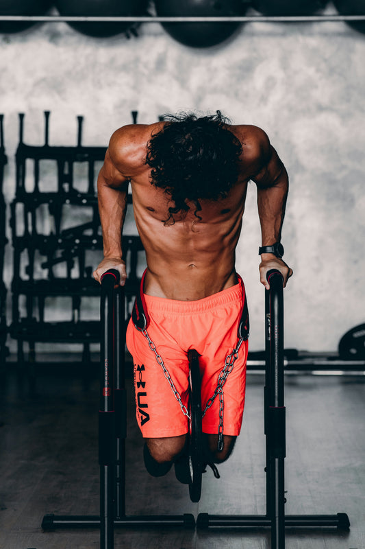 Calisthenics athlete performing weighted dips on parallel bars during a bodyweight strength workout