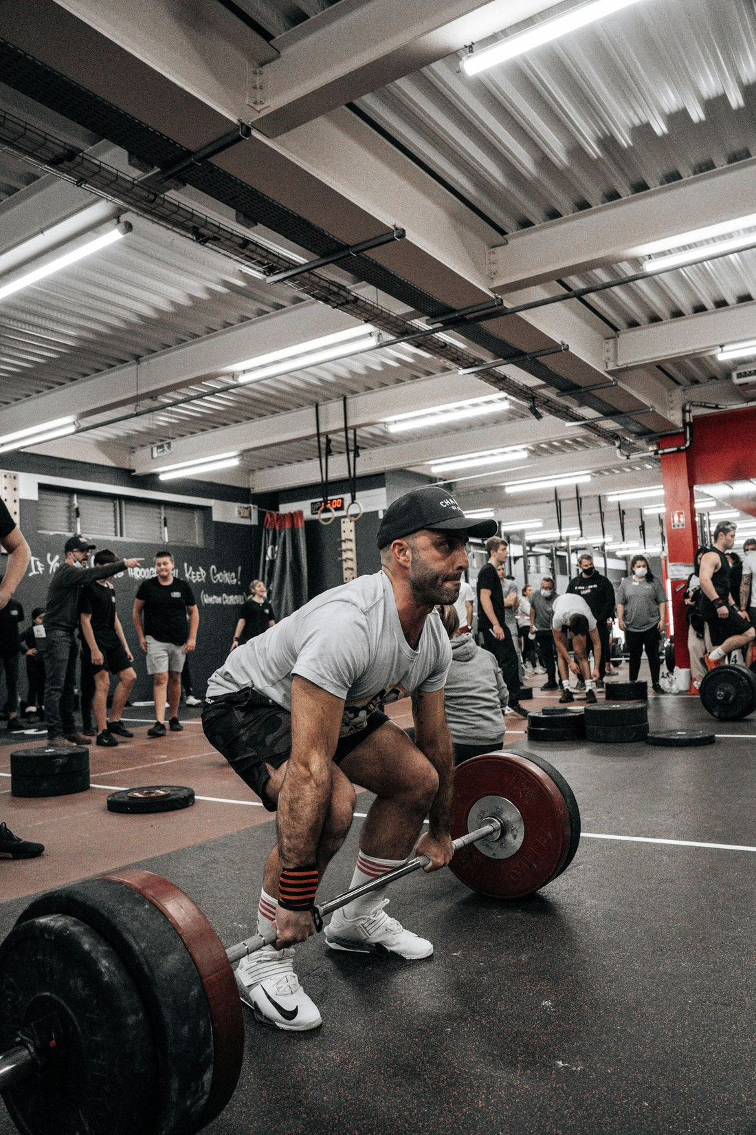 Man performing a controlled barbell squat in a gym
