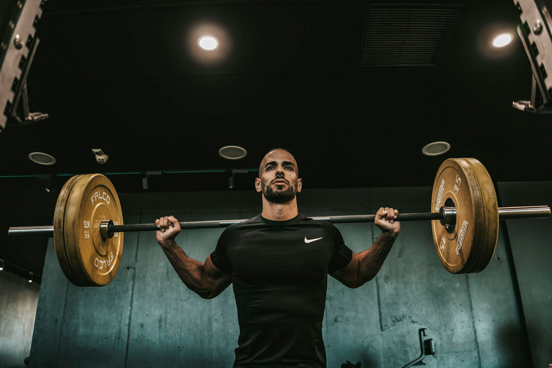 Male athlete preparing for a barbell squat in a real gym, representing focused strength training