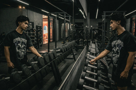 An athlete selecting a dumbbell from a rack in a modern weight room