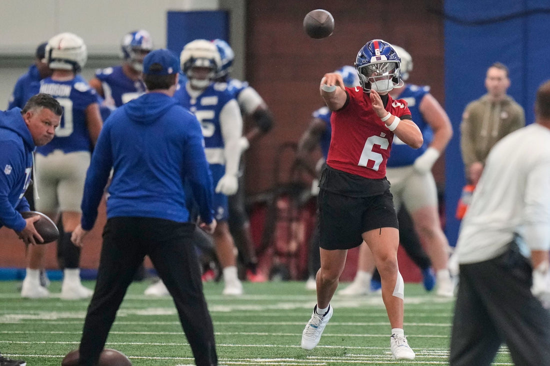 New York Giants quarterback Jaxson Dart throwing during team practice in a red jersey