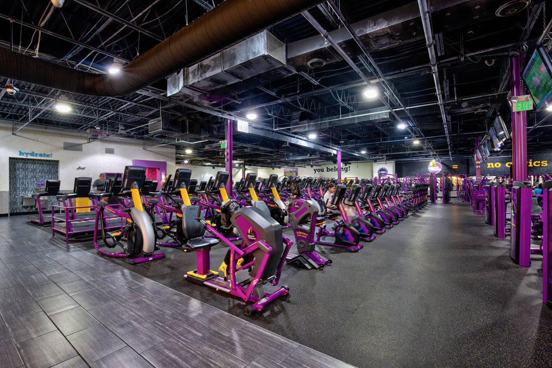 Planet Fitness gym interior with rows of purple and yellow exercise machines
