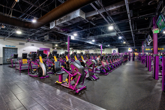 Planet Fitness gym interior with rows of purple and yellow exercise machines