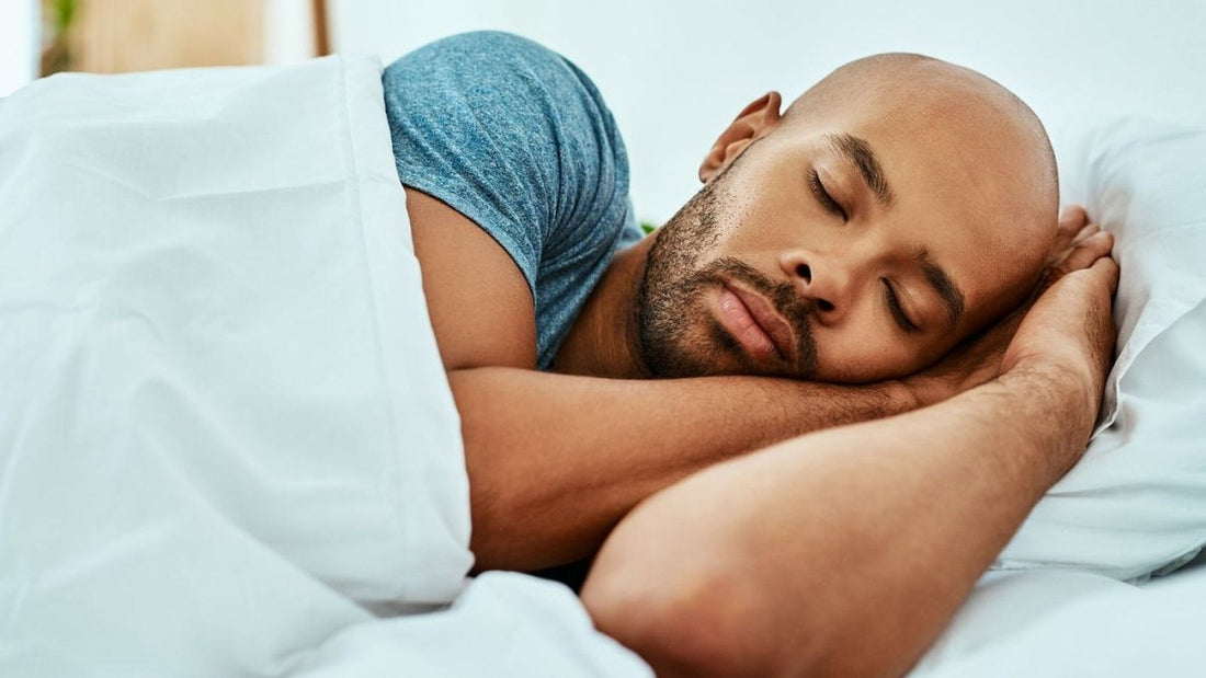 Man sleeping peacefully on his side against a white pillow, illustrating restorative sleep for lifters
