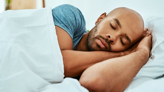 Man sleeping peacefully on his side against a white pillow, illustrating restorative sleep for lifters