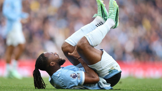 Antoine Semenyo lies on the pitch in Manchester City's 2026 home kit after suffering a knee injury
