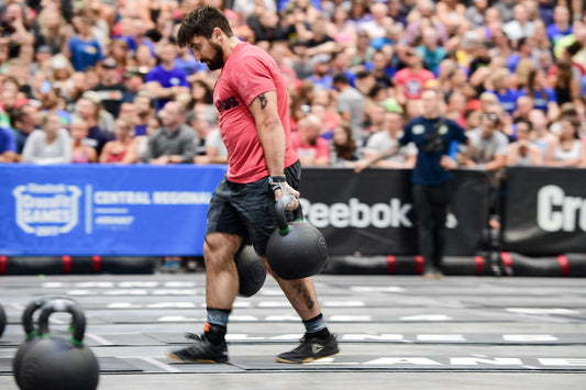 Functional-fitness athlete carrying a kettlebell during a hybrid race