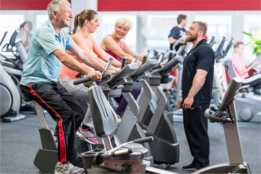 Older adults cycling on stationary bikes in a supervised fitness class