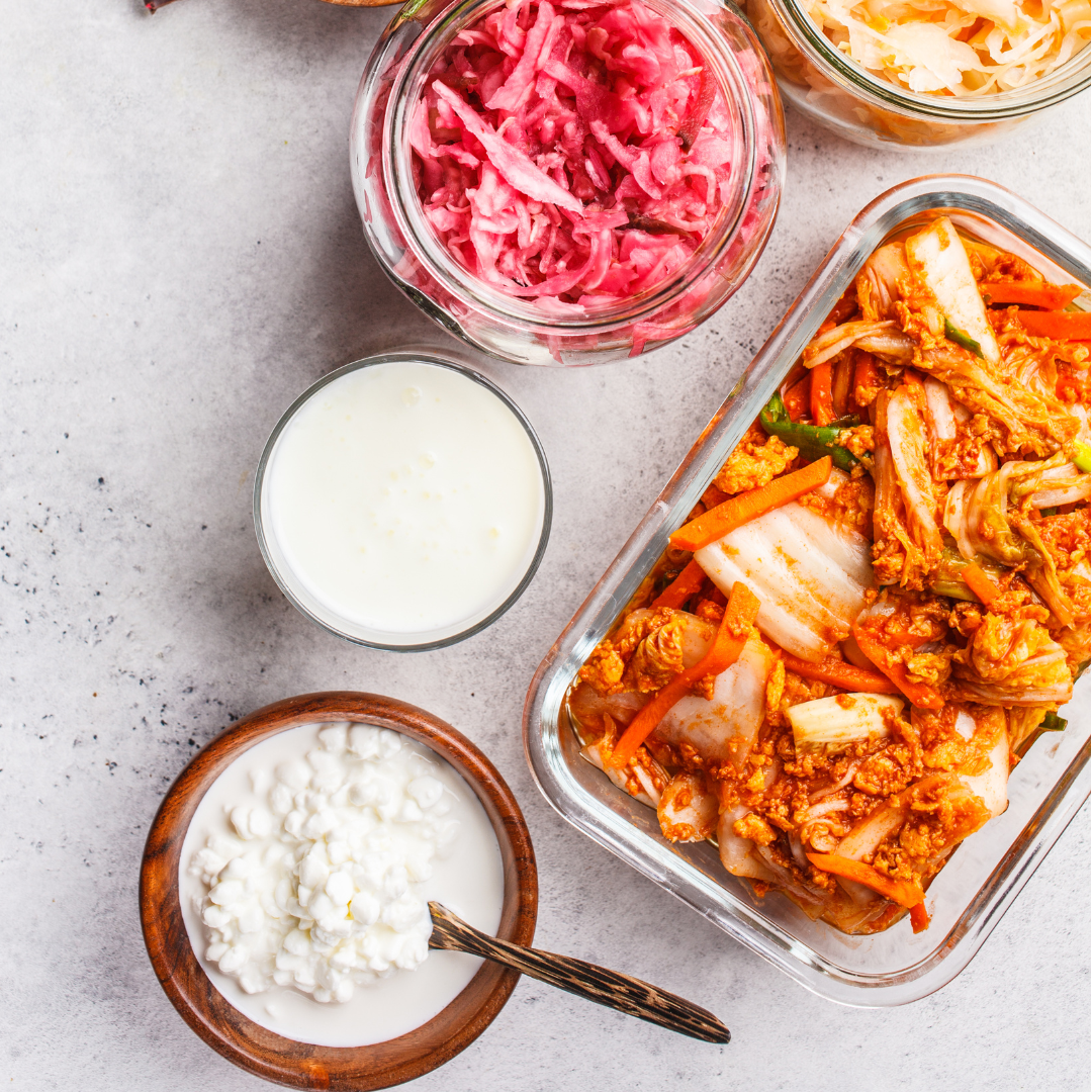 Overhead spread of kimchi, fermented vegetables, kefir and cultured dairy on a tabletop