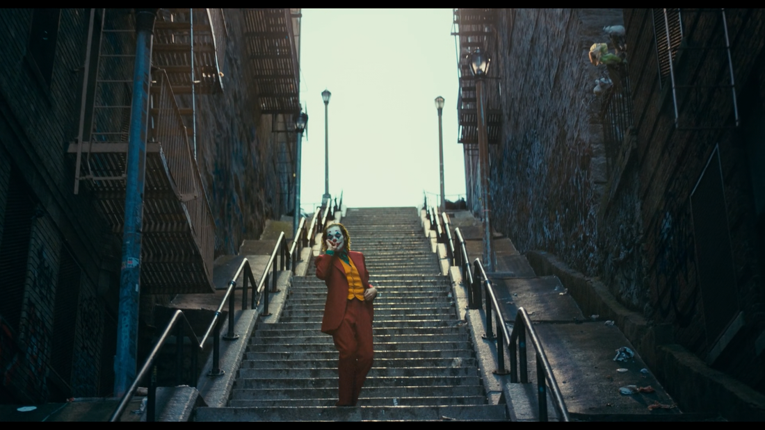 Joker in red suit moving on Gotham stairway