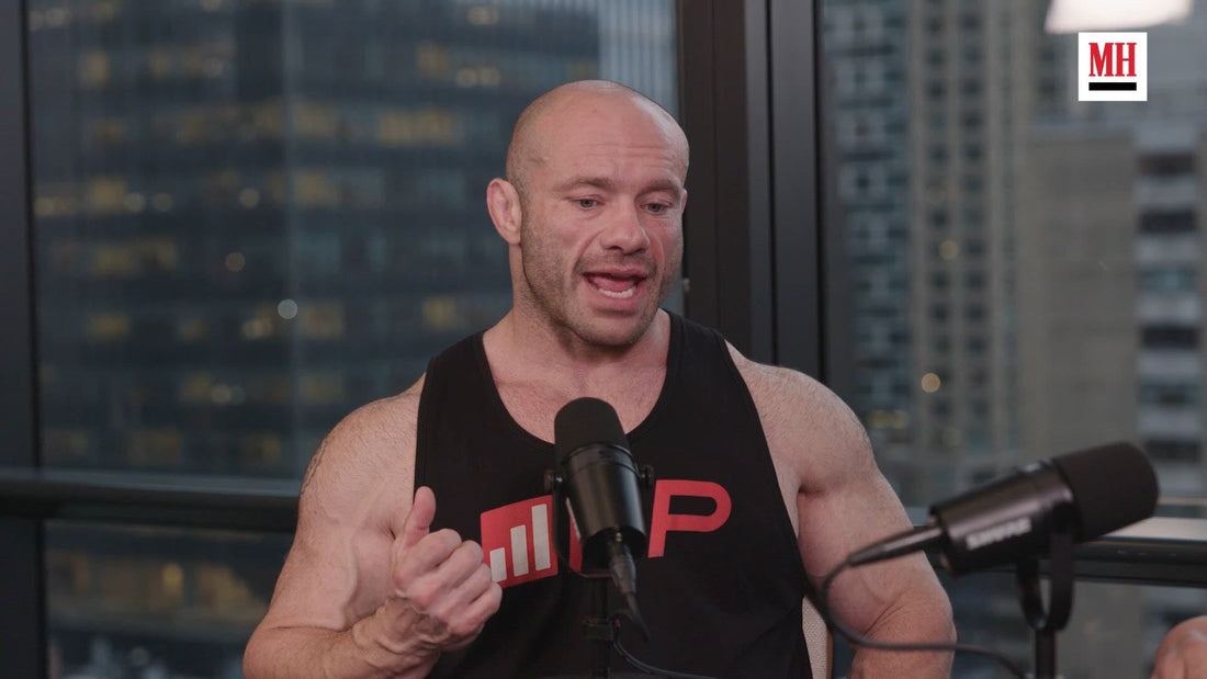 Mike Israetel speaking in a studio wearing a black Renaissance Periodization training shirt
