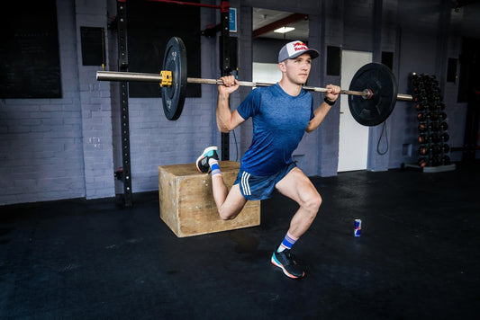 Distance runner training leg strength with a barbell lunge in a gym