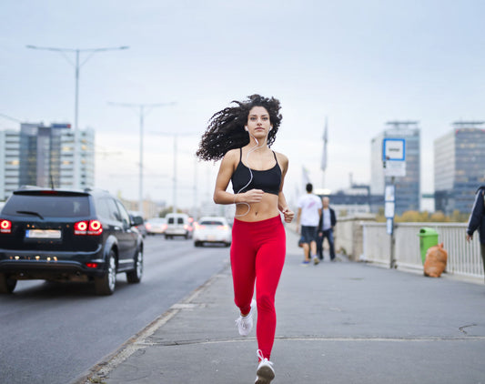 Runner wearing earphones on a city street for a hip-hop 5K playlist