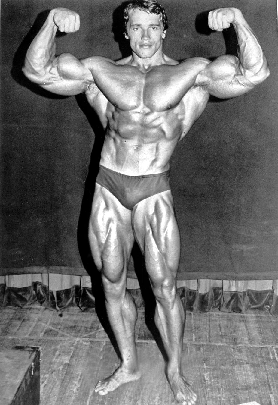 Arnold Schwarzenegger posing during his bodybuilding career in 1974