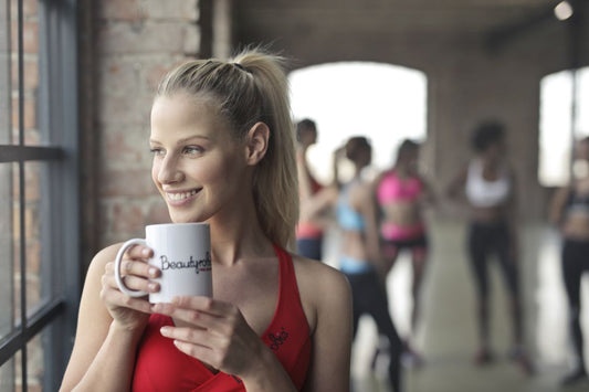 Athlete drinking coffee in a gym before training