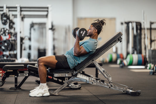 Athlete performing an incline dumbbell curl during a muscle-growth workout