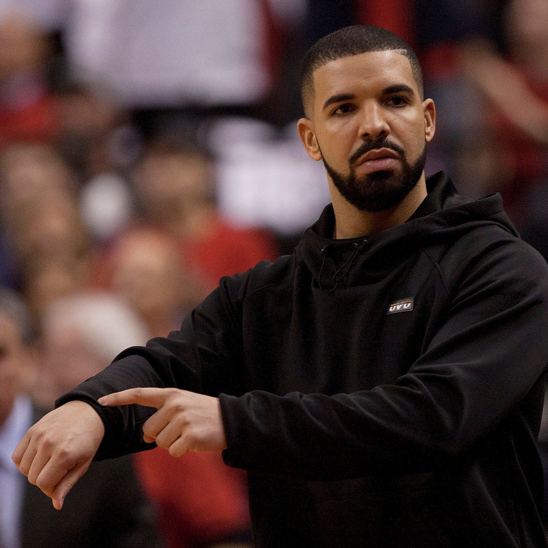 Drake wearing a dark hoodie in a casual streetwear look