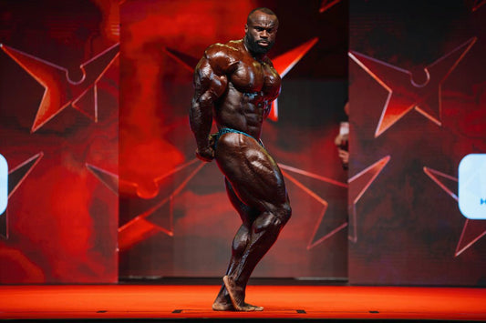 Samson Dauda posing on a professional bodybuilding stage