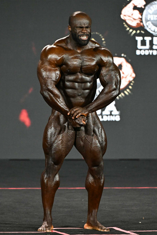 Samson Dauda posing on the Mr. Olympia stage