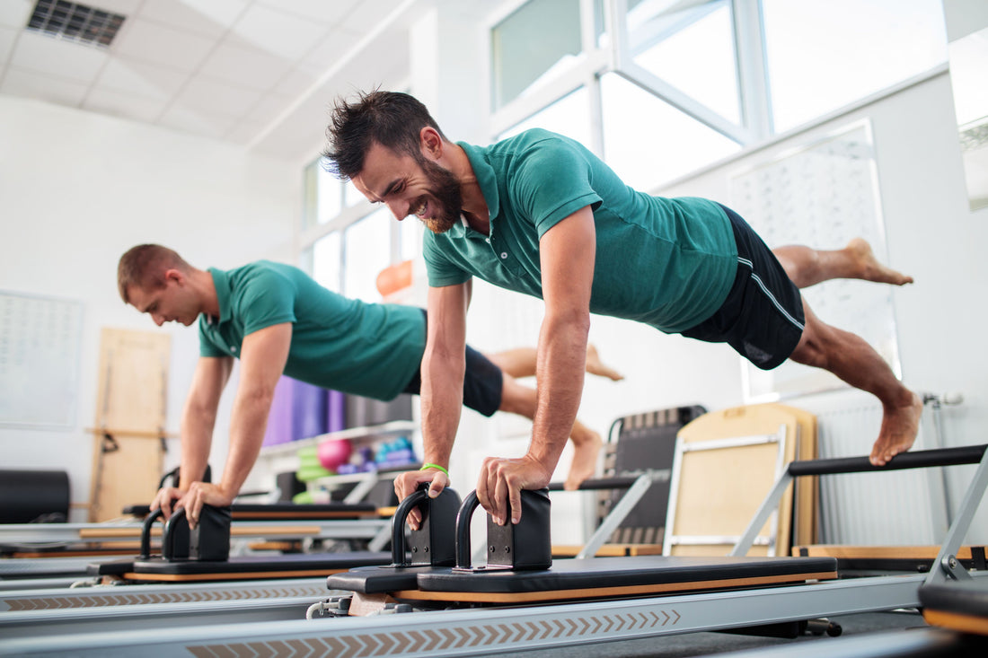Men training on Pilates reformers