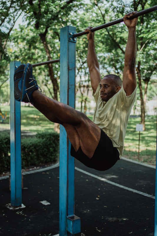 Athlete performing a strict hanging leg raise on an outdoor pull-up bar
