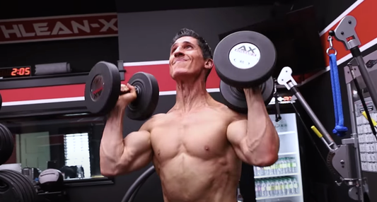 Jeff Cavaliere performing a dumbbell shoulder press