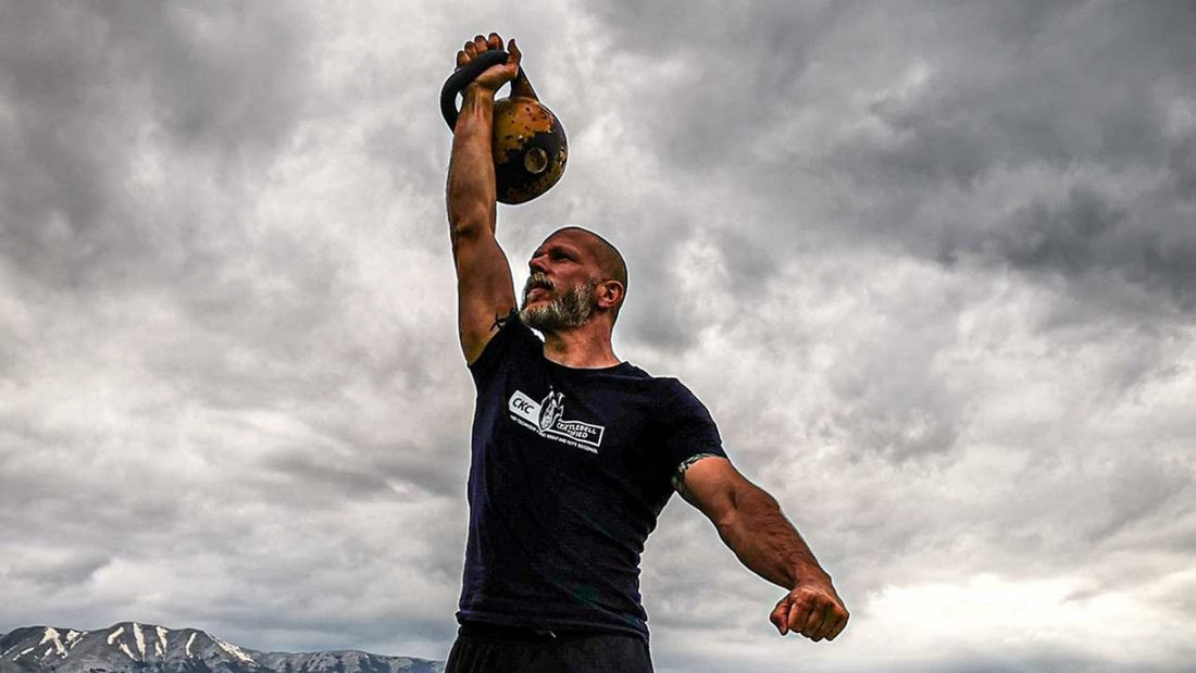 Athlete performing a strict single-arm kettlebell overhead press