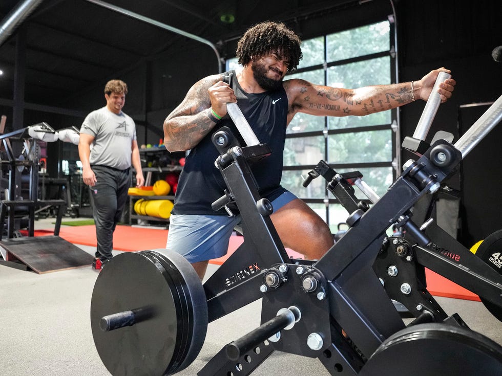 Lane Johnson training on a push-pull strength machine at his strongman-style camp