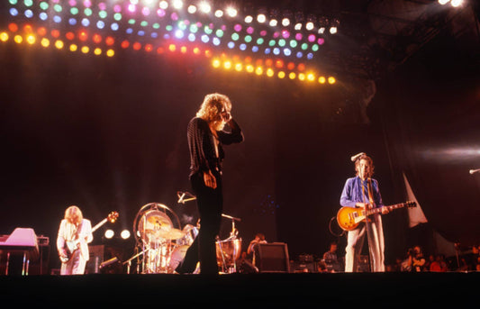 Led Zeppelin performing live under dramatic stage lights during a high-energy rock concert