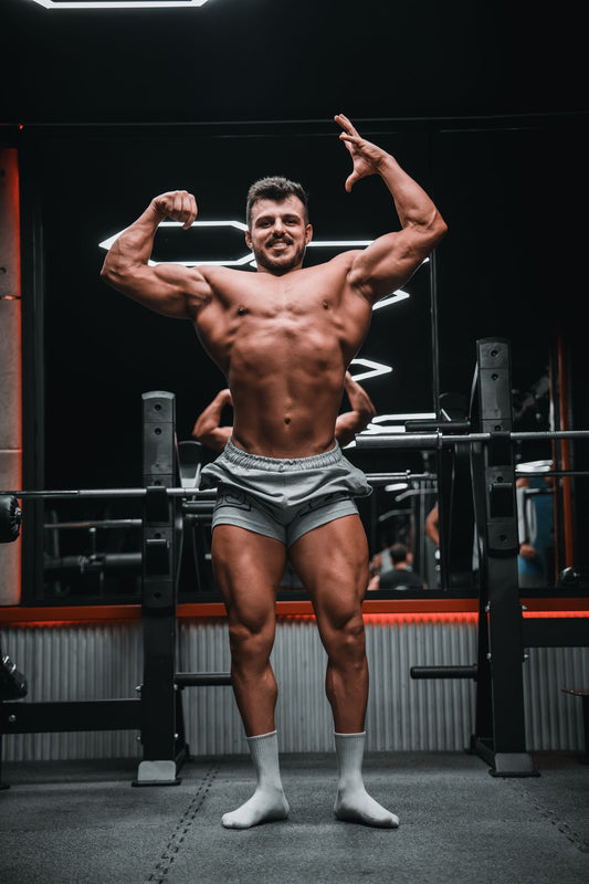 Muscular bodybuilder posing in a real gym