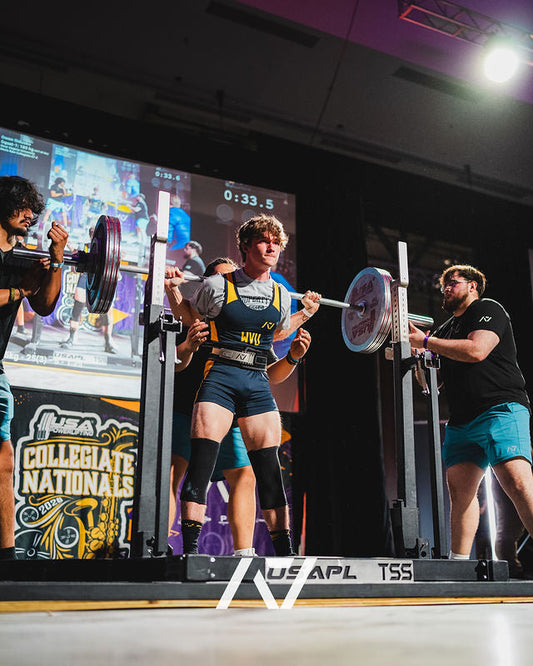 Powerlifter squatting on a USA Powerlifting competition platform