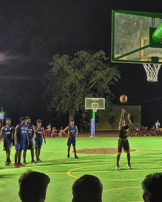 Adults playing basketball in an indoor gym
