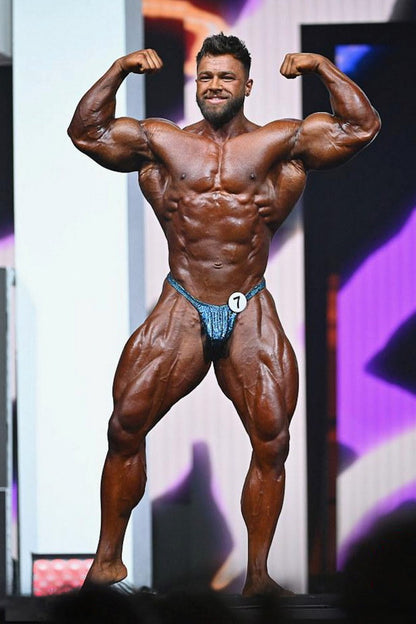 Regan Grimes posing on a professional bodybuilding stage