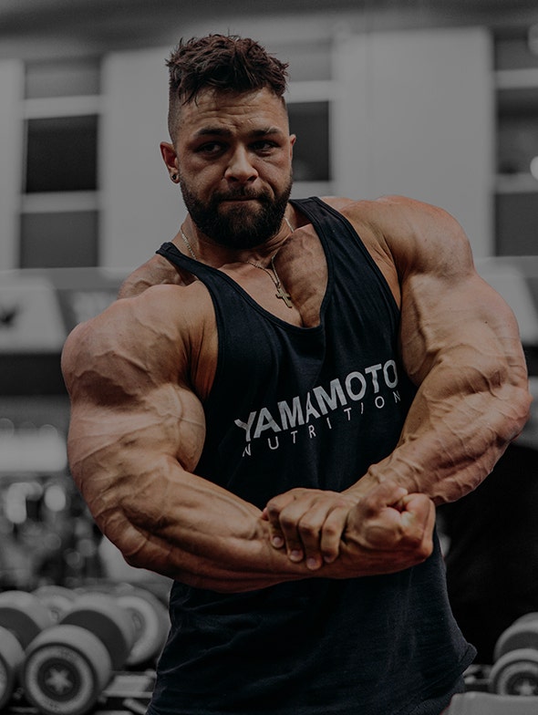 Regan Grimes posing in a gym during bodybuilding training