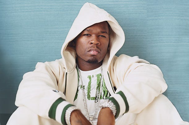 50 Cent in an oversized white hoodie, reflecting early-2000s hip-hop style