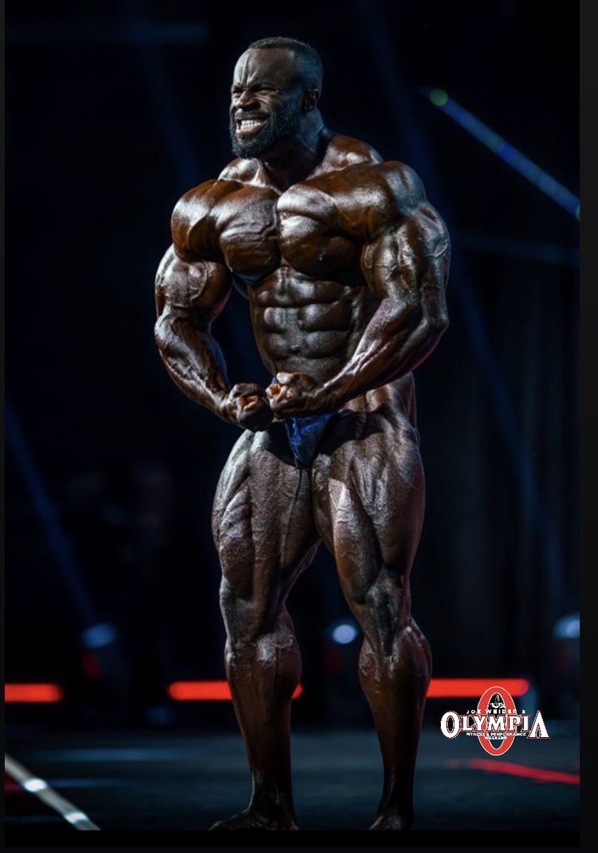 Samson Dauda posing on a bodybuilding stage