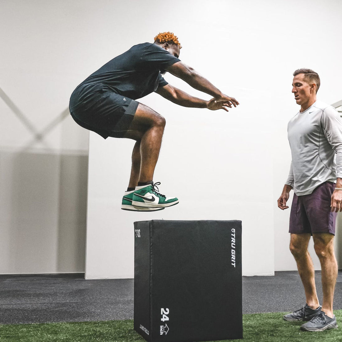 Athlete performing an explosive box jump in a gym
